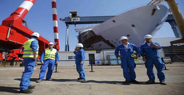 Ship builders are seen in front of the Harmony of the Seas ( Oasis 3 ) class ship at the STX Les Chantiers de l'Atlantique shipyard site in Saint-Nazaire
